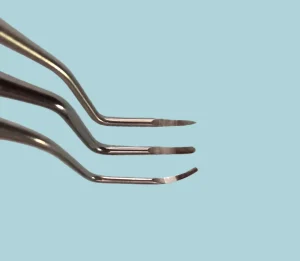 Unterschied Kürette Scaler: drei dentale Handinstrumente mit spitzen und gerundeten Arbeitsenden im Vergleich